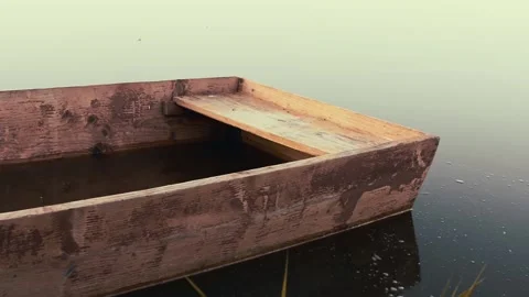 View from the water surface with reflections to the flooded wooden boat Stock Footage 132240098