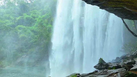 View of a waterfall from inside a cave in Tropical paradise Stock Footage 252088730