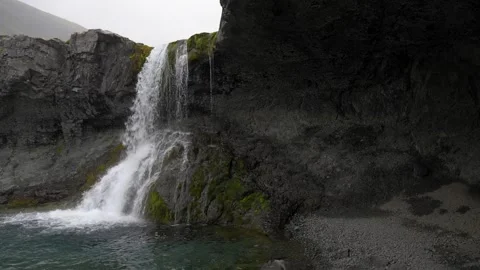 View of a waterfall from inside a rocky cave in Iceland 4K nature footage Stock Footage 339926429