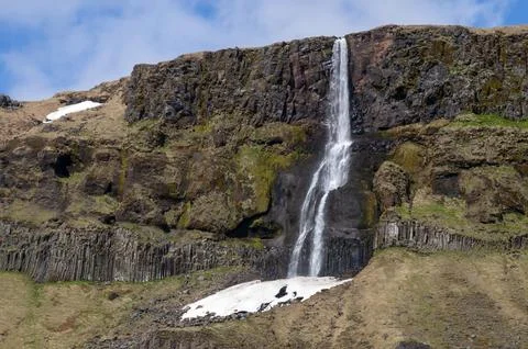 View of waterfall with patch of snow at bottom Foto stock