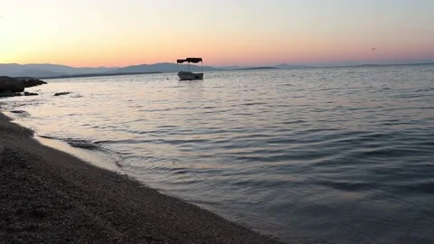 View of waves and the boat on the beach at the sunrise Stock Footage 134392197
