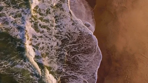 A view of the waves arriving at the beach and leaving a wet track on the sand. Stock Footage 77507450