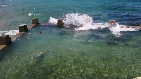 View of waves hitting the coast and Aussi people swimming near Coogee beach,  Stock Footage 86297061
