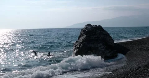 View of Waves Rolled at Sea Coast Line With Huge Rock With People Swiming Stock Footage 68819277