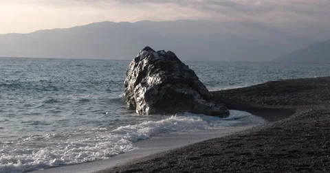 View of Waves Rolled at Sea Coast Line With Huge Rock at Sunset Stockbeeldmateriaal 68819355