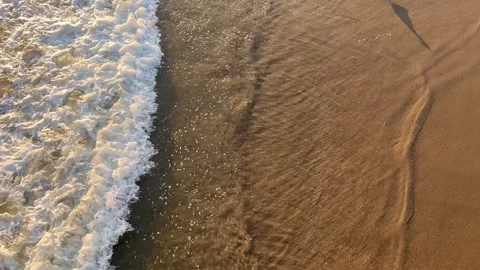 View of waves rushing in on the sand from above Stock Footage 247409649
