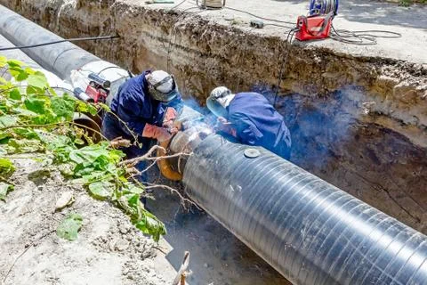 View on welding team of welders until them assembly a new pipeline Stock Photos