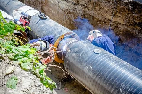 View on welding team of welders until them assembly a new pipeline Stock Photos