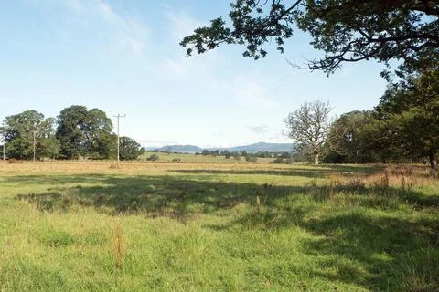 View to the west across fields to distant Ben Lomond and Conic Hill. Stock Photos
