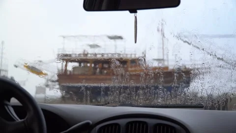 View from the wet window of the car on the ship standing on the shore Stock Footage 231980146
