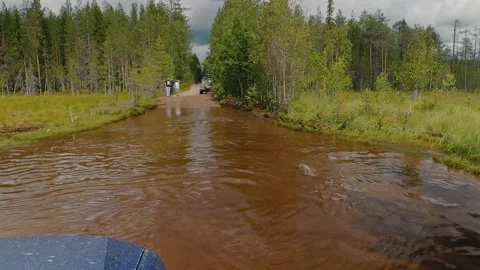 View of a wheel passing through a long puddle from the window of a moving car. Stock Footage 143313756
