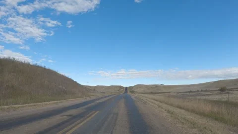 View while driving along a rough paved road through dry prairie ranch land under Stock Footage 306093254