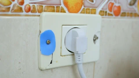 View at white broken patched up electricity socket with plug in cable Stock Footage 255377196