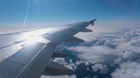 View of the white clouds and Earth from the airplane porthole. Stock Footage 231300277
