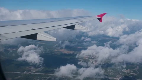 View of the white clouds and Earth from the airplane porthole. Stock Footage 231409106