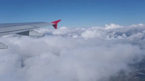 View of the white clouds and Earth from the airplane porthole. Video stock 242036525