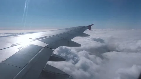 View of the white clouds and Earth from the airplane porthole. Stock Footage 258227076