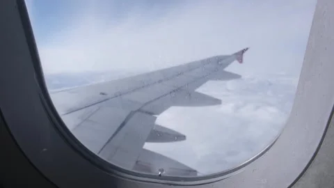 View of the white clouds and Earth through a frozen airplane porthole. Stock Footage 265259758