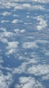 View of the white clouds and Earth from the airplane porthole. Travel concept Stock Photos