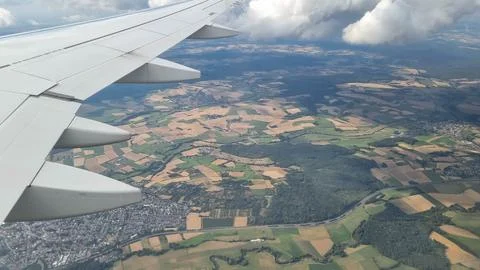 View of the white clouds and Earth from the airplane porthole. Travel concept Stock Photos