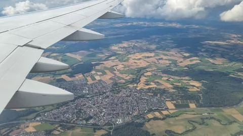 View of the white clouds and Earth from the airplane porthole. Travel concept Stock Photos