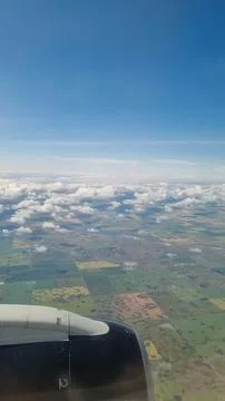 View of the white clouds and Earth from the airplane porthole. Travel concept Stock Photos