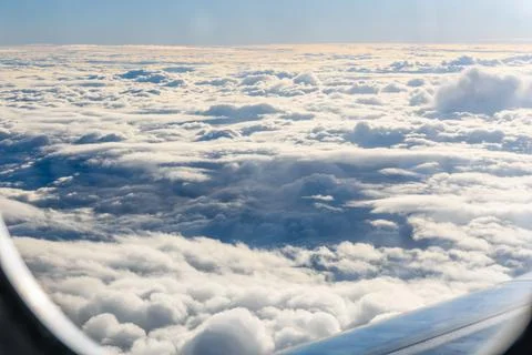 View on white clouds and wing from the airplane window Stock Photos