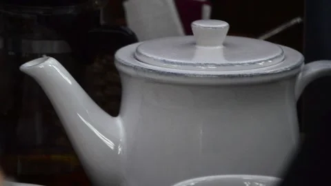 View of a white, retro vintage, ceramic teapot in a dark interior. 動画素材 129710902