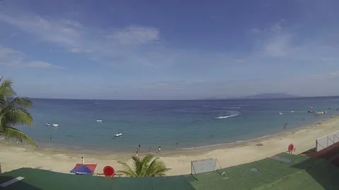 View of white sand beach with blue skies and tourists enjoying the beach Stock Footage 134024654