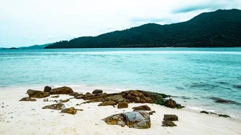 View of white sand beach with rocks Stock Photos