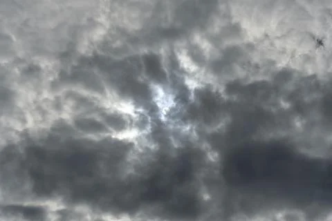 View of the white solar disk in the dark clouds. No land view. Stock Photos