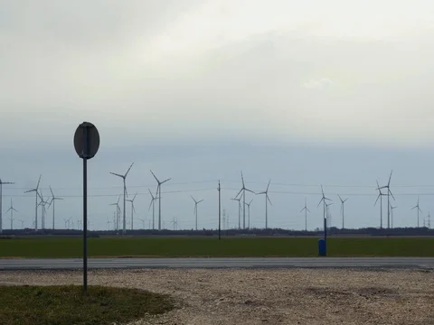 View of white SUV car passing by windmill farm. Stock Footage 79987667