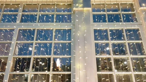 View of the white window of the building, decorated with a festive garland of Stock Footage 143496526