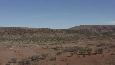 View of a wide plain, ridge, and a moving vehicle Stock Footage 190964583