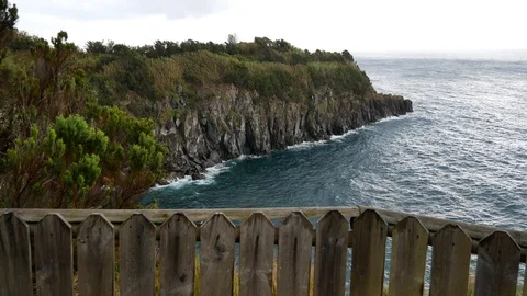 View of wild atlantic ocean through a fence in windy cloudy weather Video stock 127892796