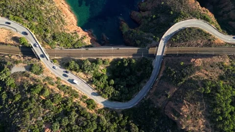 View of a winding road along steep cliffs above the turquoise Mediterranean Sea Stock Footage 319549558