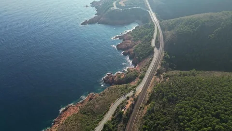 View of a winding road along steep cliffs above the turquoise Mediterranean Sea Stock Footage 319549559