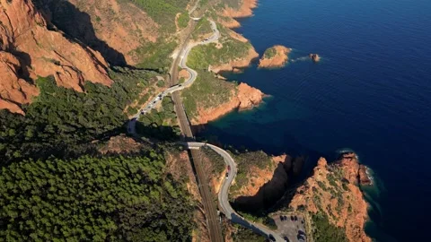 View of a winding road along steep cliffs above the turquoise Mediterranean Sea Stock Footage 319549561