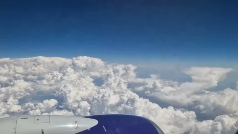The view from the window of an air plane to the clouds, blue sunny sky. Stock Footage 274270797