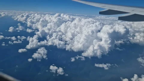The view from the window of an air plane to the clouds, blue sunny sky. Video stock 274499720