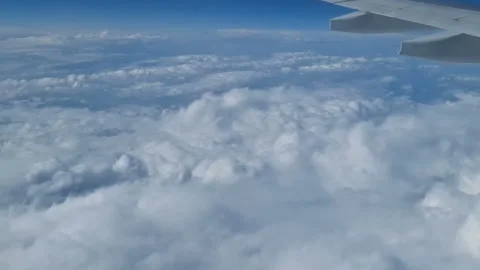 The view from the window of an air plane to the clouds, blue sunny sky. Stock Footage 276104683
