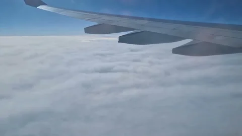 The view from the window of an air plane to the clouds, blue sunny sky. Stock Footage 276105690
