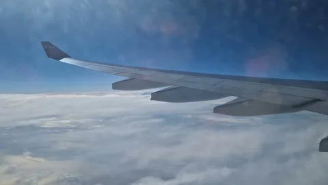 The view from the window of an air plane to the clouds, blue sunny sky. Stock Footage 276105851