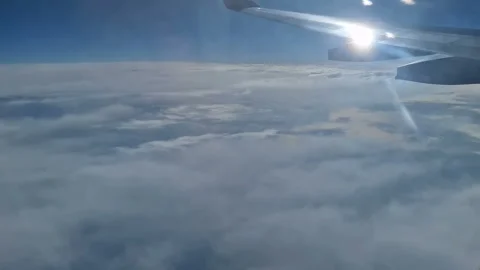 The view from the window of an air plane of clouds and blue sunny sky. Stock Footage 276424797