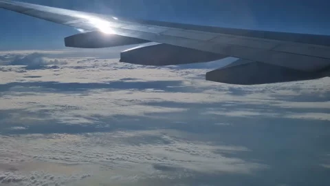 The view from the window of an air plane of clouds and blue sunny sky. Video stock 276740746