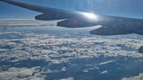 The view from the window of an air plane of clouds and blue sunny sky. Stock Footage 277439411