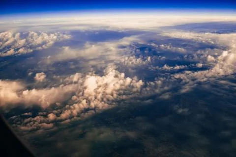 View from the window of the aircraft on the clouds and the ground from a height Stock Photos