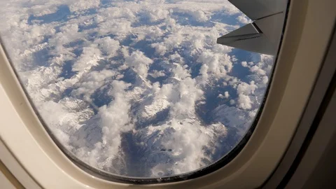 View From Window Of Aircraft On Mountain Massif In Snow And Clouds With Glacier Video stock 126580508