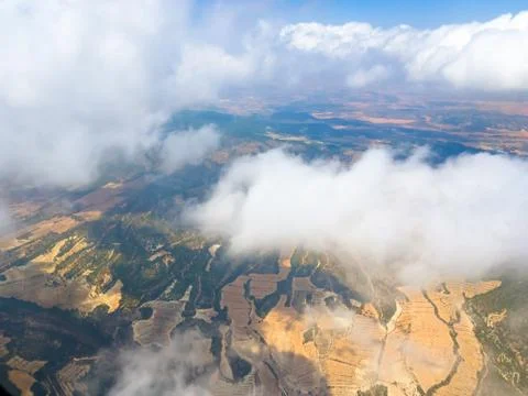 View from the window of the aircraft: mountains, fields, roads, villages, clo Stock Photos