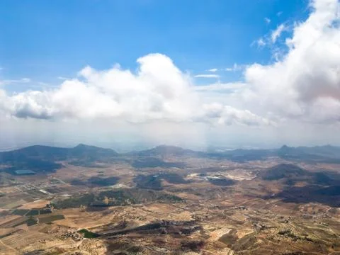 View from the window of the aircraft: mountains, fields, roads, villages, clo Stock Photos